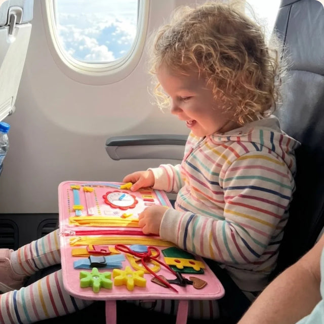 Toddler playing with the Busy Board on a plane